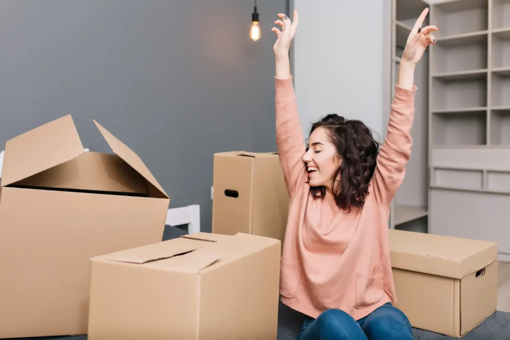 chica empacando sus cosas en cajas de carton